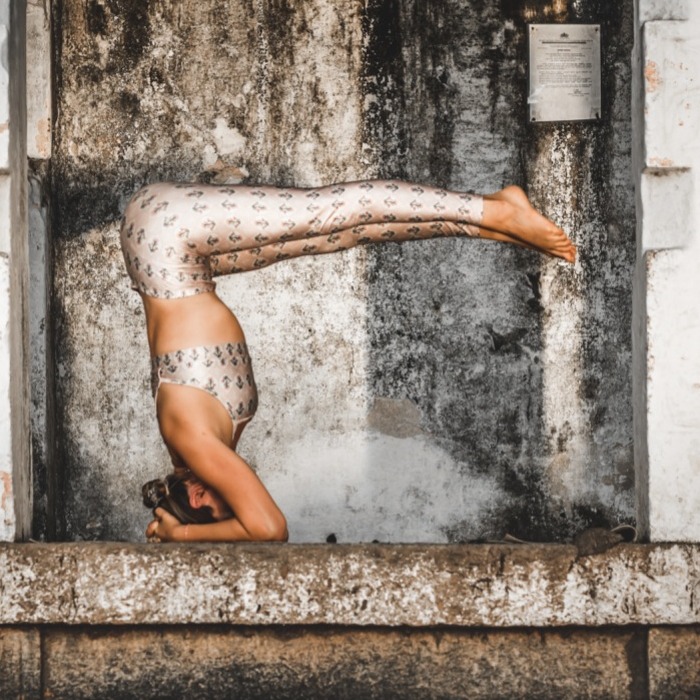 Anna in a forearm balance in a weathered stone doorway