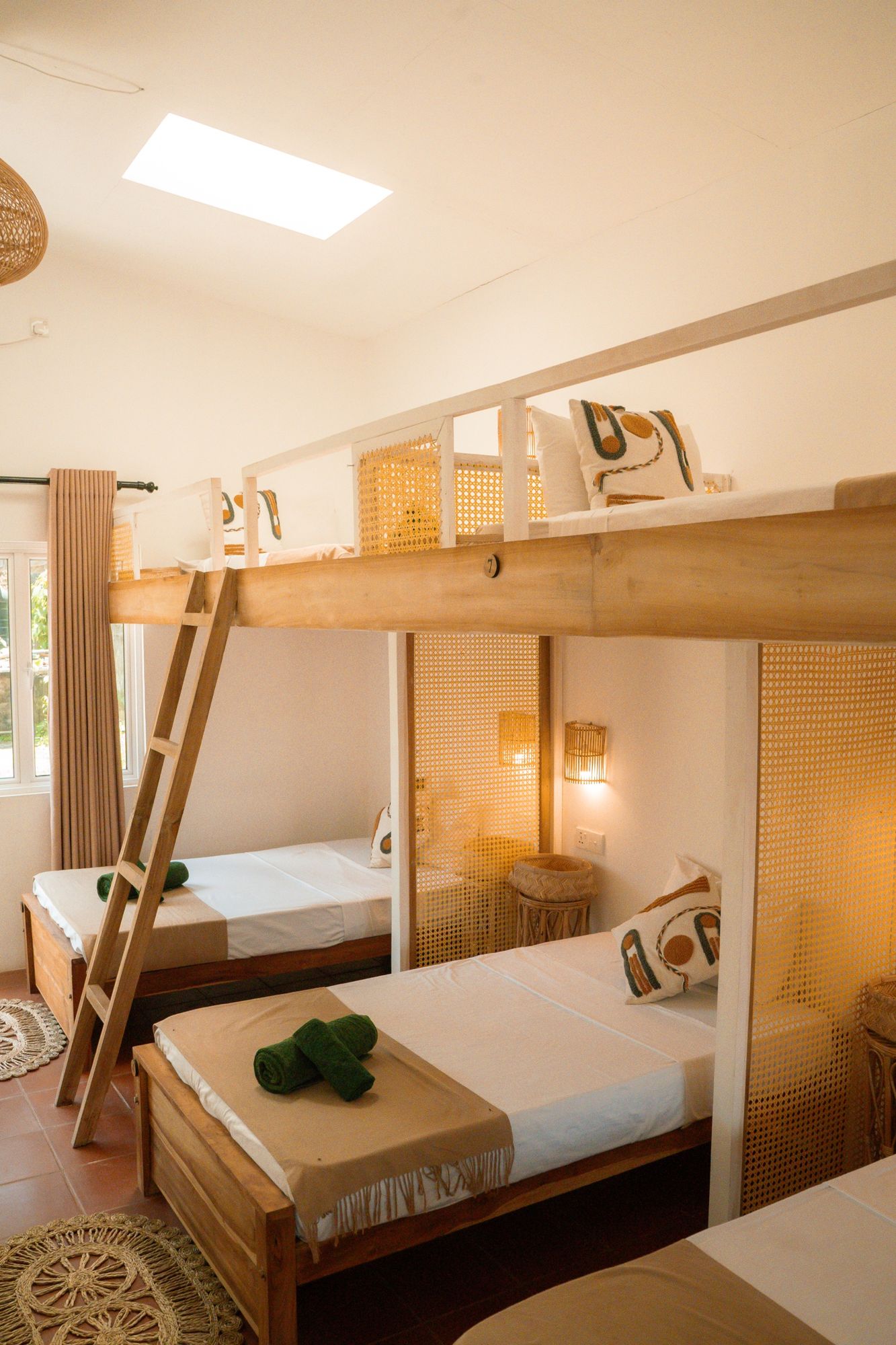 Bunks with cane privacy screens under a skylight