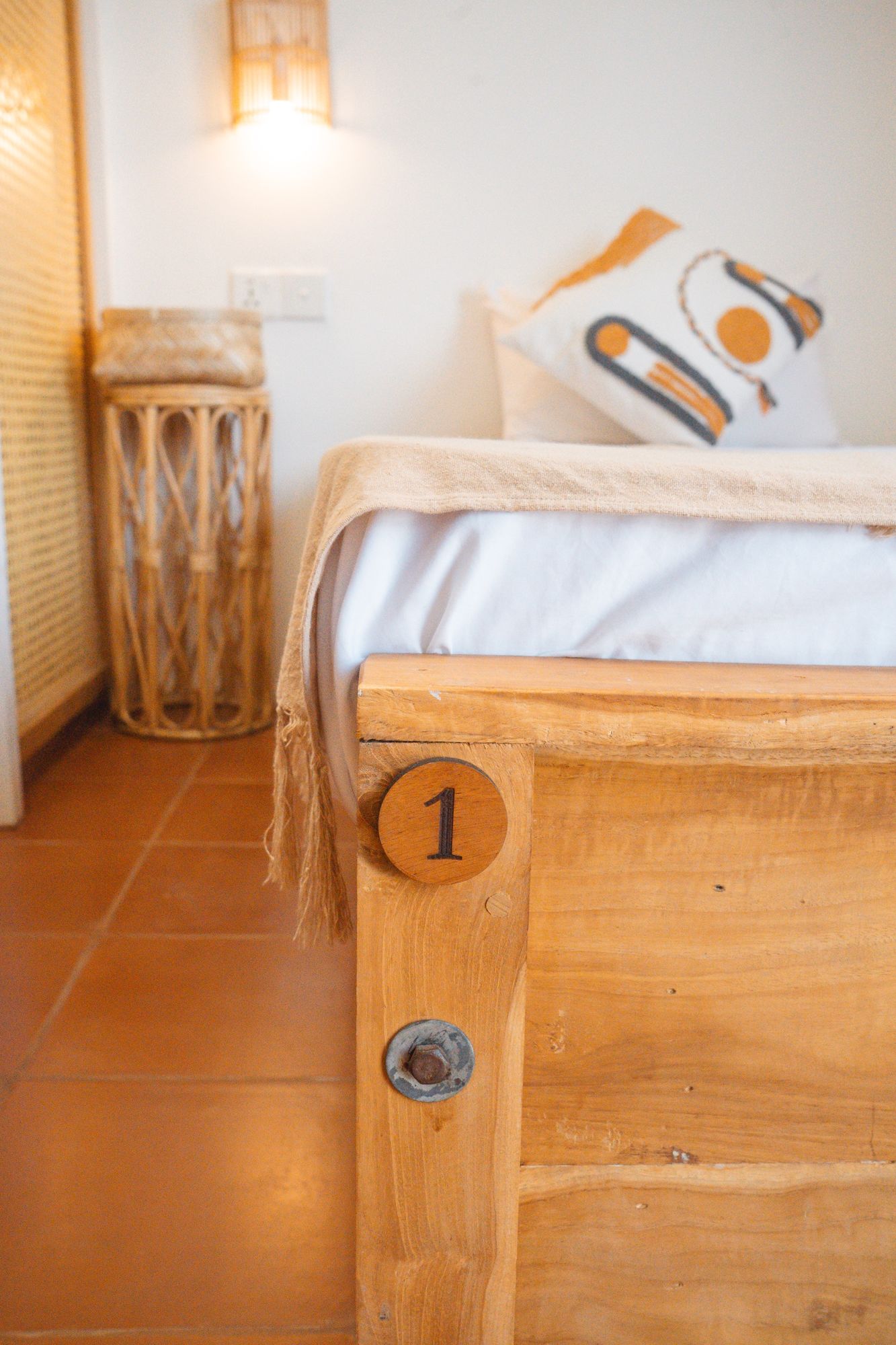 Numbered teak bed and rattan side stool