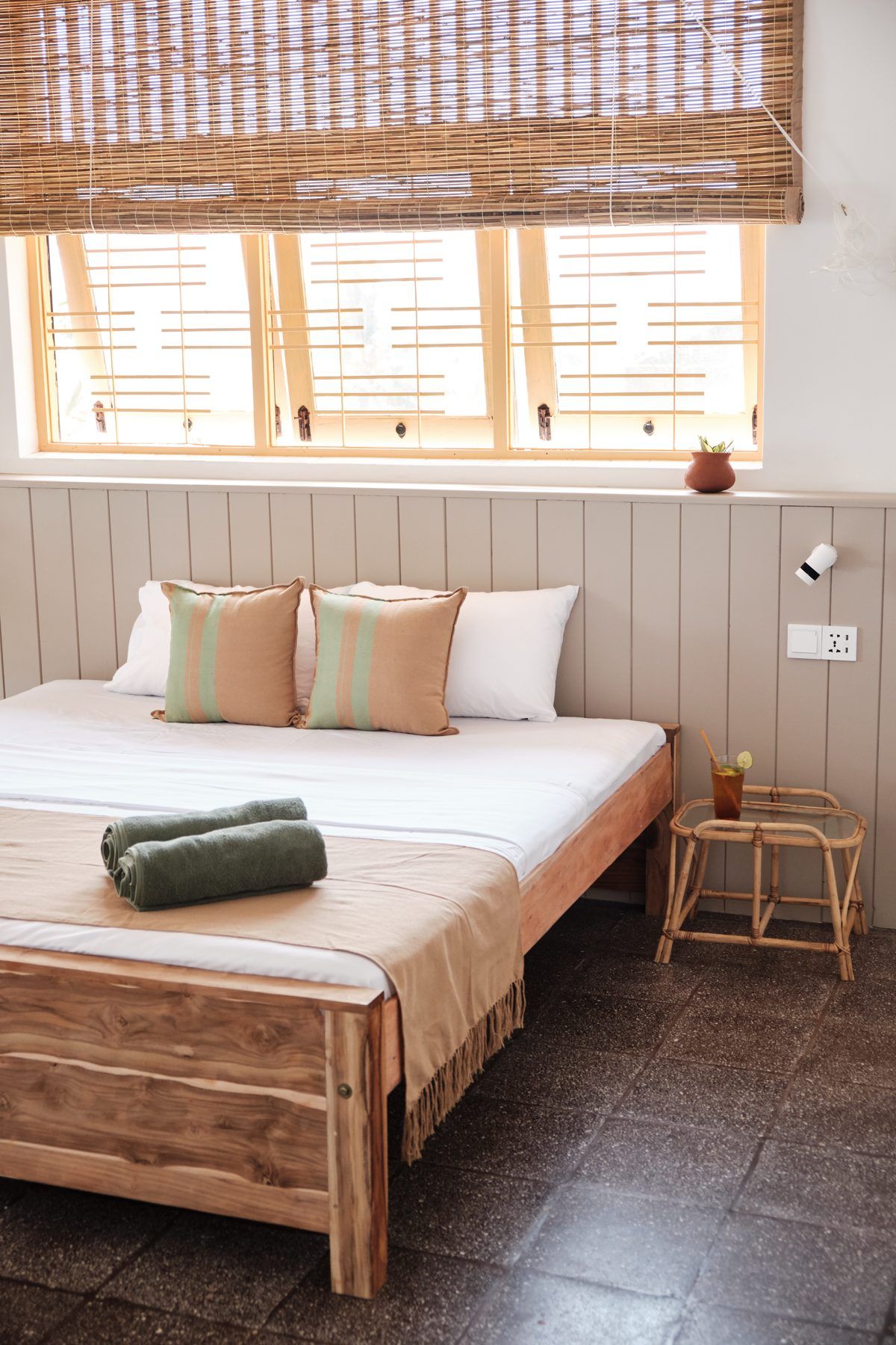 Queen room, bed under bamboo blinds
