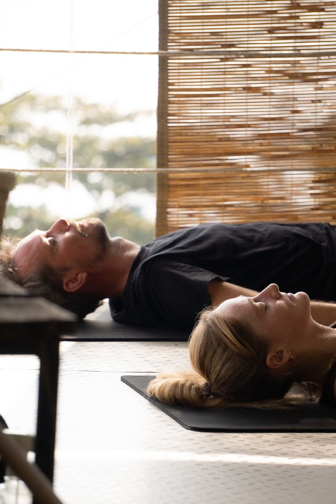Savasana, students resting on mats with the hills beyond